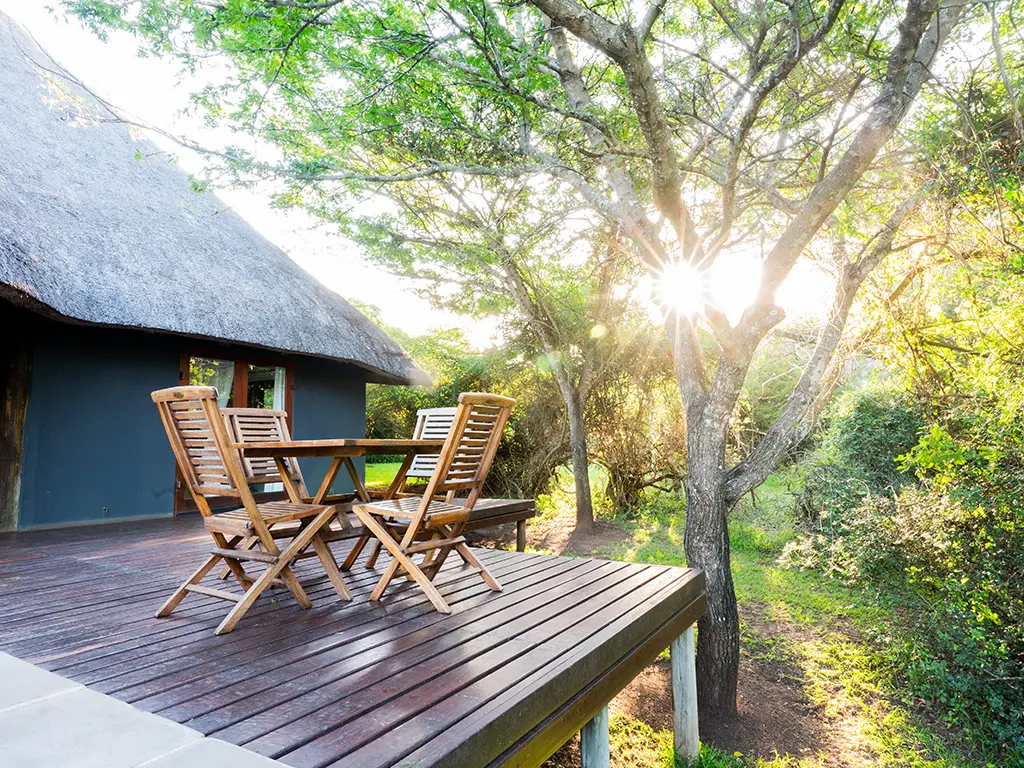View of of the outside deck of the Cottage at Rhino River Lodge, with a seating area for guests to enjoy.